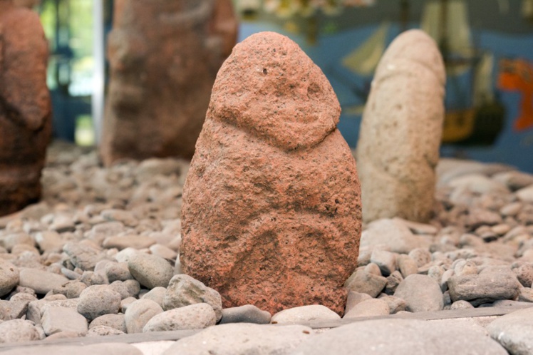 Tiki en pierre rouge du Musée de Tahiti et des îles qui ressemble au tiki Vahine ura. Tiki en pierre rouge du Musée de Tahiti et des îles qui ressemble au tiki Vahine ura.