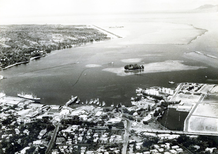 Vue aérienne du port de Papeete avec le petit îlot de Motu Uta vers 1950