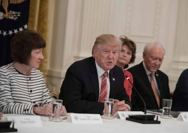 Le président américain Donald Trump entouré par les sénatrices républicaines Susan Collins (G) et Lisa Murkowski (D) le 27 juin 2017 à la Maison blanche à Washington ( AFP/Archives / NICHOLAS KAMM )