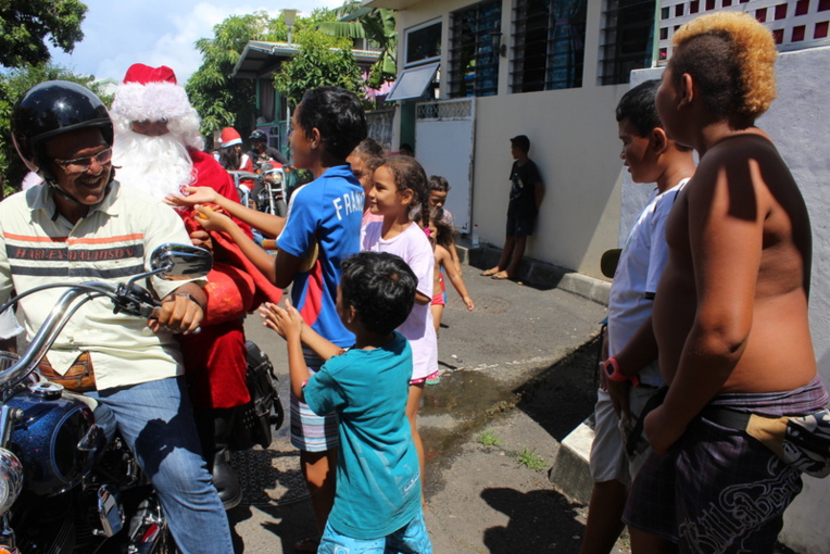 Le Père Noël est passé en moto distribuer des bonbons dans les différents quartiers défavorisés de Papeete.