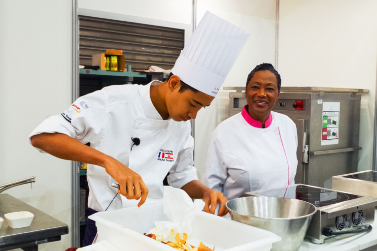 Le jeune Tehuiarii Papaura confectionne son panier surprise sous les yeux de Babette de Rozières. Le jeune Tehuiarii Papaura confectionne son panier surprise sous les yeux de Babette de Rozières.