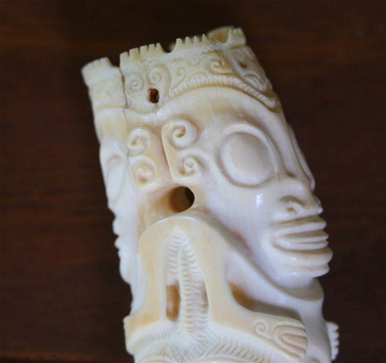 Gros plan sur la partie supérieure d’une dent de cachalot gravée. Gros plan sur la partie supérieure d’une dent de cachalot gravée.