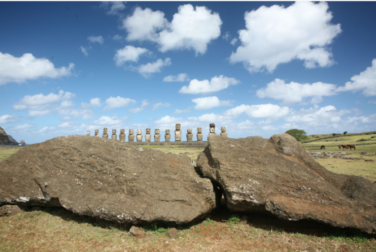 A l’arrière-plan, l’ahu Tongariki. Au premier plan un moai brisé pendant son transport vers un ahu proche de celui du Tongariki.