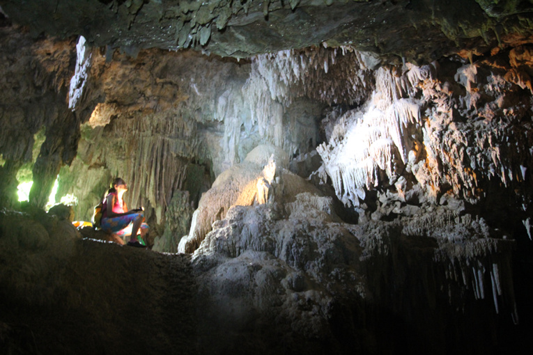 Dans l’entrée d’une grotte, lumière du jour et lumière des torches dévoilent un décor somptueux. Dans l’entrée d’une grotte, lumière du jour et lumière des torches dévoilent un décor somptueux.
