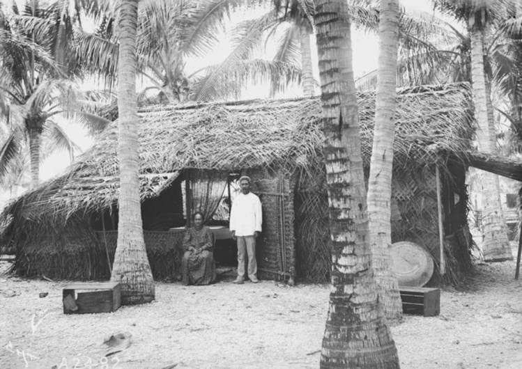 Une homme et une femme devant leur maison à Hikueru en 1900. Photo Charles Haskins. Une homme et une femme devant leur maison à Hikueru en 1900. Photo Charles Haskins.