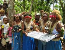 Aux Îles Salomon, des femmes tiennent un système à diodes électroluminescentes (DEL) photovoltaïque