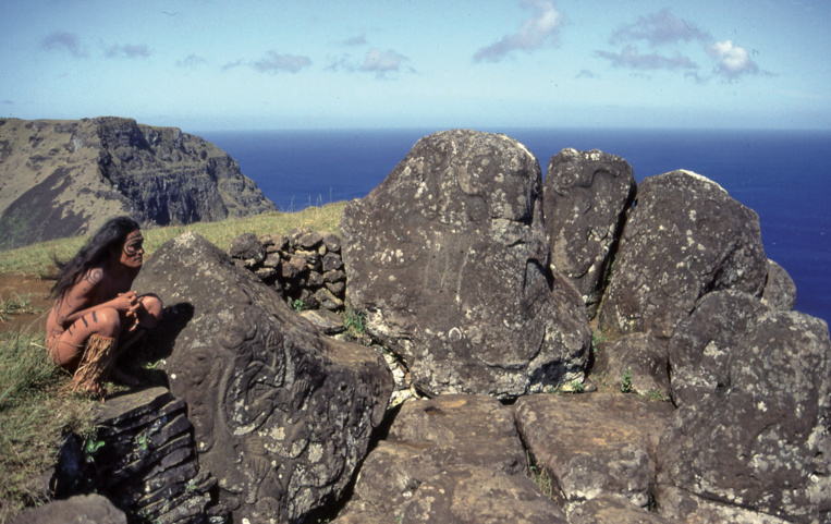 Comme jadis, sur le site le plus riche en pétroglyphes d’Orongo, un Pascuan observe les îlots au large, Motu Nui, Motu Iti et Motu Kaokao.