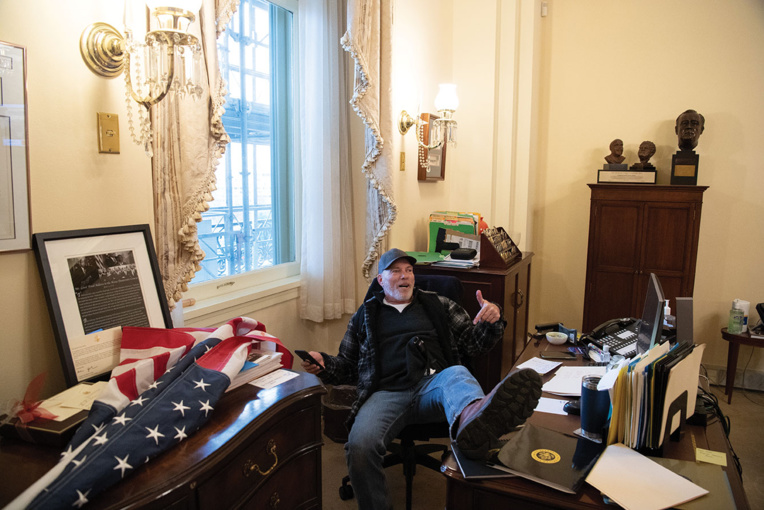 Un manifestant se fait immortaliser les pieds sur le bureau de la présidente de la Chambre, Nancy Pelosi.