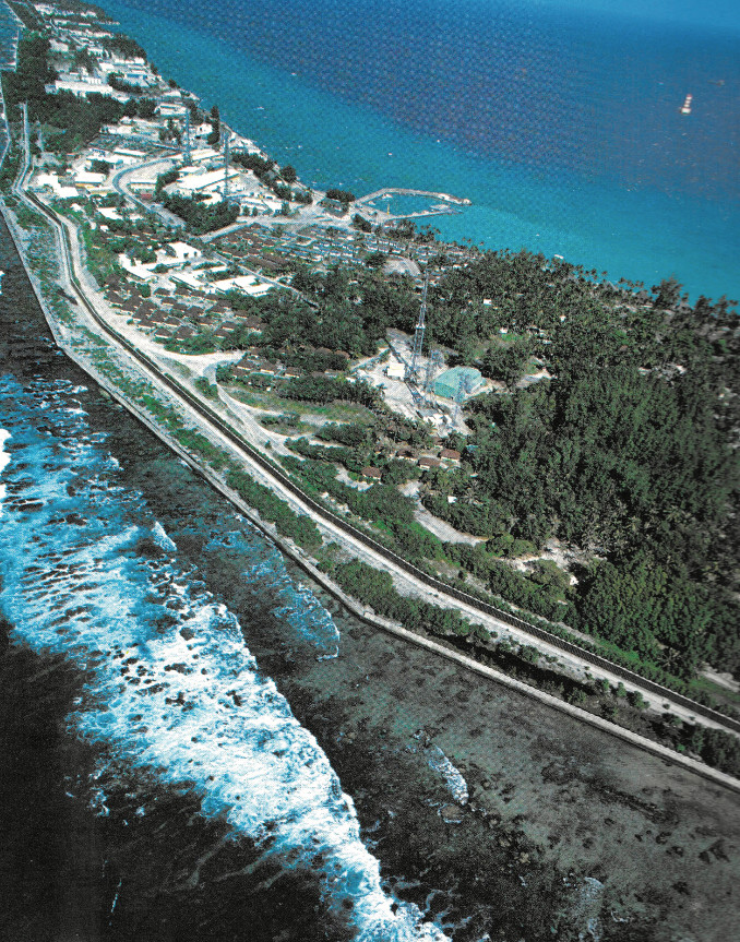 Une vue aérienne partielle de la base-vie de Moruroa avec son double mur de béton pour la protéger des assauts éventuels de l’océan.
