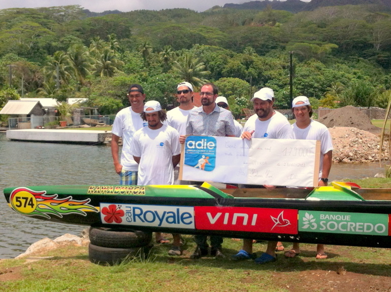 Le club de va'a "Hotua Hoe" posant avec le directeur régional de l'Adie en Polynésie, Olivier Pôté tenant un "gros" chèque de sponsoring.