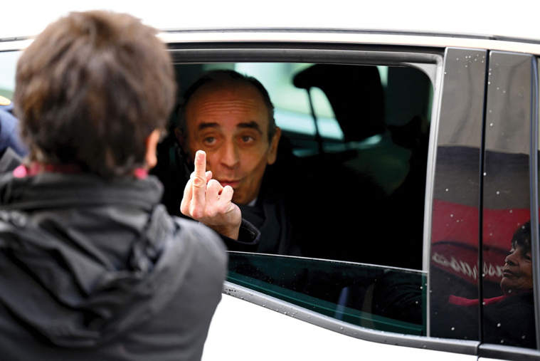 Nicolas TUCAT / AFP - Une photo de l'AFP a provoqué l'émoi samedi au terme d'une visite mouvementée d’Éric Zemmour à Marseille. A la sortie d'un restaurant où le polémiste venait de déjeuner, une passante lui a fait un doigt d'honneur. Le polémiste - qui pourrait annoncer mardi ou mercredi sa candidature, selon plusieurs sources - a répondu par le même geste en affirmant "et bien profond", sous le regard amusé de sa conseillère Sarah Knafo, a constaté un photographe de l'AFP.