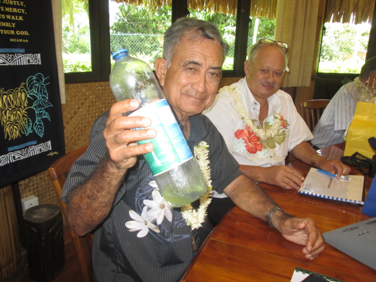 Le maire de Fa'a'a, Oscar Temaru, tenant une bouteille contenant du carburant fabriqué à partir de capuchons en plastique.