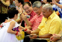 Le Contre-amiral Premier ministre Franck Bainimarama (droite), accompagné de l’ambassadeur de Chine à Suva, Huang Yong (gauche), reçoit un cadeau d’une fillette, Chu Chu Shau, lors des célébrations du Nouvel An à l’école Yat Sen (Source photo : Ministère