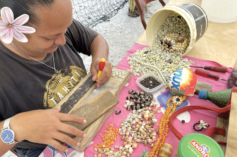 Hina en train de piquer les coquillages pour réaliser une parure de bijoux. Hina en train de piquer les coquillages pour réaliser une parure de bijoux.