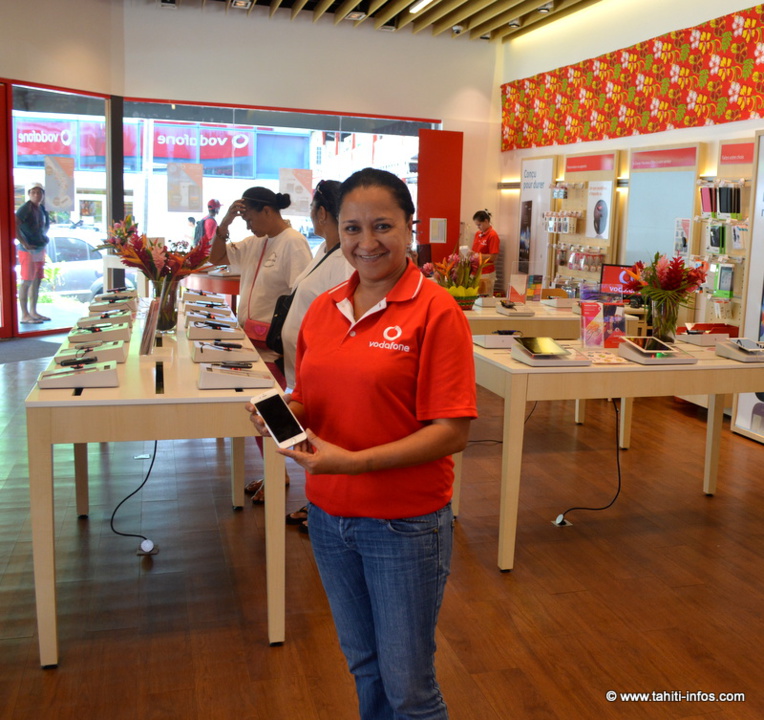 La boutique Vodafone où une vendeuse montre un iPhone 6 La boutique Vodafone où une vendeuse montre un iPhone 6
