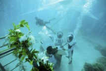 À Bora Bora, les organisateurs de mariage ont l'habitude des demandes extravagantes, cette fois c'est un club de plongée local qui organise des cérémonies nuptiales en scaphandre immergée dans le lagon de Bora. PHOTO GREGOIRE LE BACON, AFP