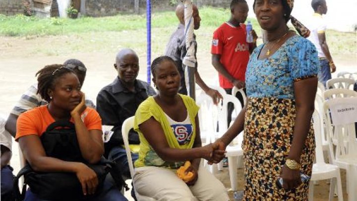 AFP / Par Zoom DOSSO | Béatrice Yordolo, dernière rescapée connue du virus Ebola au Libéria le 22 mars 2015 avec sa famille lors d'une visite de la responsable de l'Organisation mondiale de la Santé (OMS) pour l'Afrique Matshidiso Moeti à Zuma