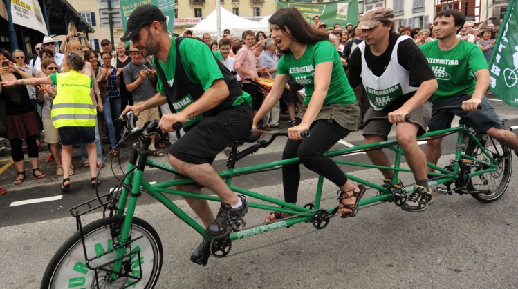 Des gens pédalent sur un vélo à quatre places lors du départ d'un tour de l'Hexagone de 5.600 km pour lutter contre le réchauffement climatique, lancé par le mouvement écologiste Alternatiba, le 5 juin 2015  afp.com/IROZ GAIZKA