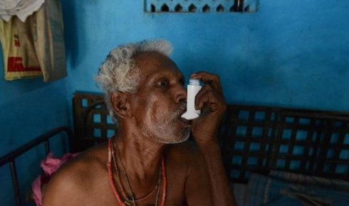 Chinnapan Chinnakannu utilise son inhalateur, le 7 mai 2015 chez lui près de Ahmedabad, pour surmonter ses difficultés respiratoires après des années de travail dans une usine d'amiante ciment en Inde (AFP - SAM PANTHAKY)