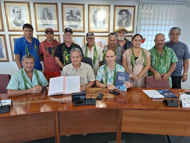 Les trois signataires de la convention, Clément Vergnhes, président de la fédération des rāhui Te Marae Mo’a, Donatien Tanret, représentant de Pew, et Winiki Sage, président de la Fape, entourés des référents des ZPR de Tahiti (Crédit : Anne-Charlotte Lehartel).