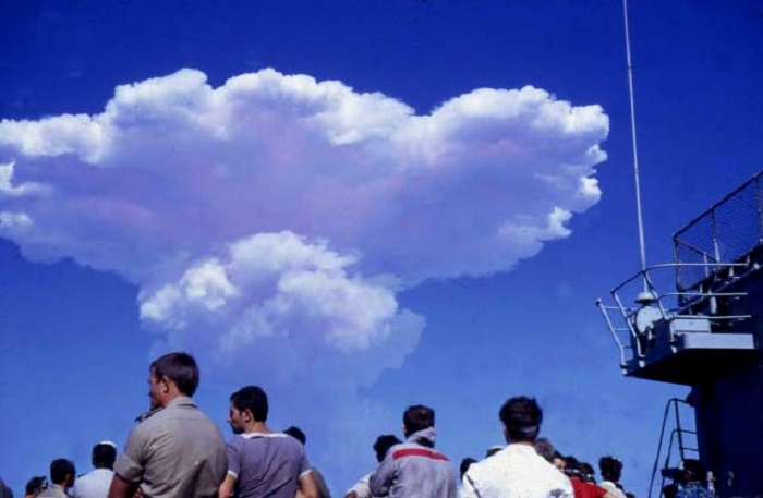 Un tir d'essai nucléaire en 1970 en Polynésie française : les militaires regardent le champignon atomique se dissiper dans l'atmosphère (source : moruroa.org).
