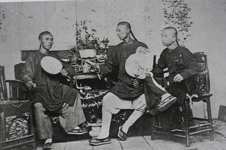 Trois jeunes chinois assis chez eux dans les années 1970. Crédit John Hall.