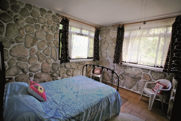 Une chambre “cosy” à l’ancienne, tout en corail, avec un lit datant du début du XXe siècle, à la pension Teautamatea