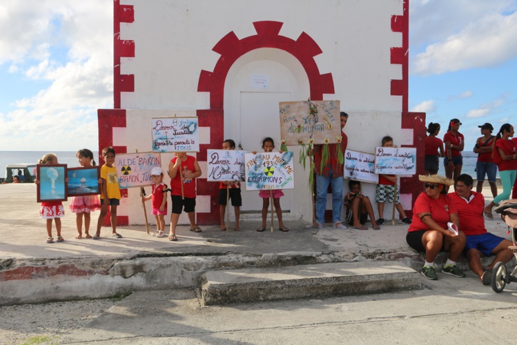 Les enfants de l’atoll se préparent à défiler avec les pancartes. Le point de rendez-vous était donné au phare de l'atoll