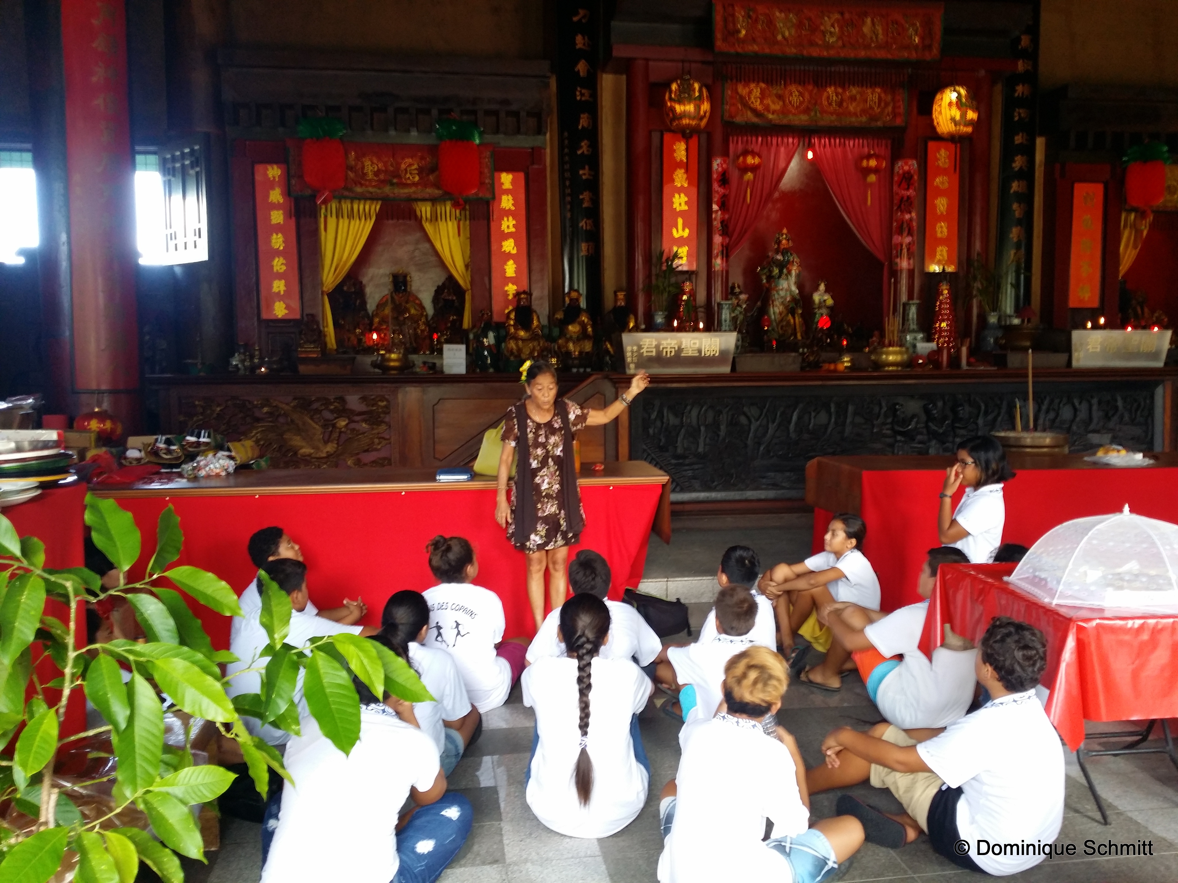 Des élèves du collège de Tiarama écoutent attentivement les explications de Germaine Chung, la responsable du Temple Kanti.
