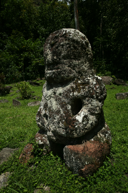Derrière Takaii se dresse un tiki de taille plus modeste, Fau Poe, qui serait l'image de son épouse.
