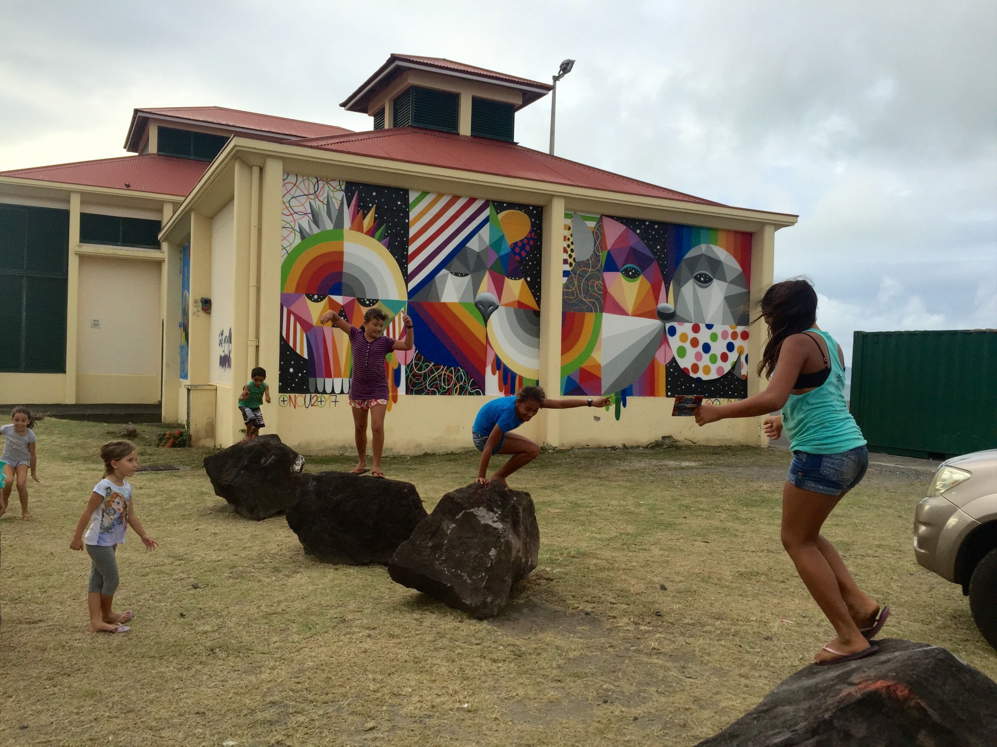 Les jeunes jouent devant le mur peint par le grand Urban artiste espagnol Okuda.
