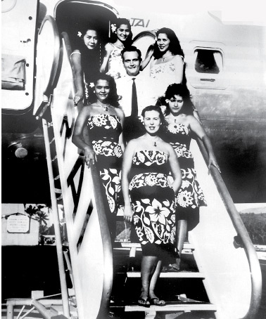 Photo de groupe des personnels RAI-TAI sur l’échelle du DC 7 C. En haut et de gauche à droite, Jeanne Teriitehau-Navarro, Madeleine Sannen et Annie Toomaru-Hirshon toutes trois navigantes. Au centre, Paul Grigorieff, chef d’escale, à gauche, Rose-Mary Sanquer-Blouin, Maguy Malinowski et Galina Grigorieff.