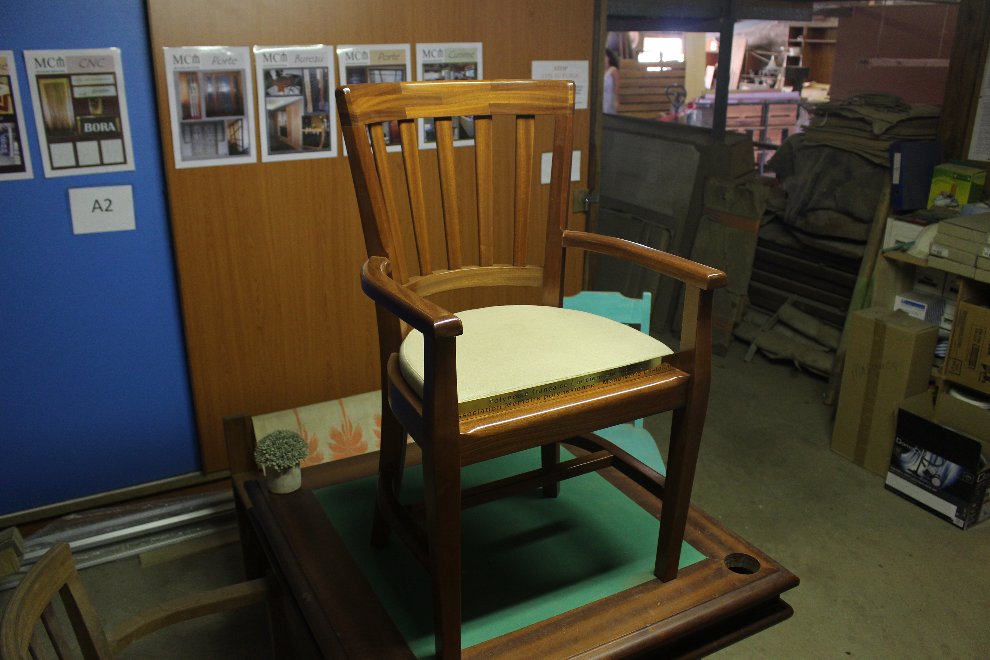 La chaise a été commandée par l’association Mémoire polynésienne, elle a été conçue et fabriquée par la menuiserie Castellani. La plaque en laiton a été réalisée par Tahiti Sign.