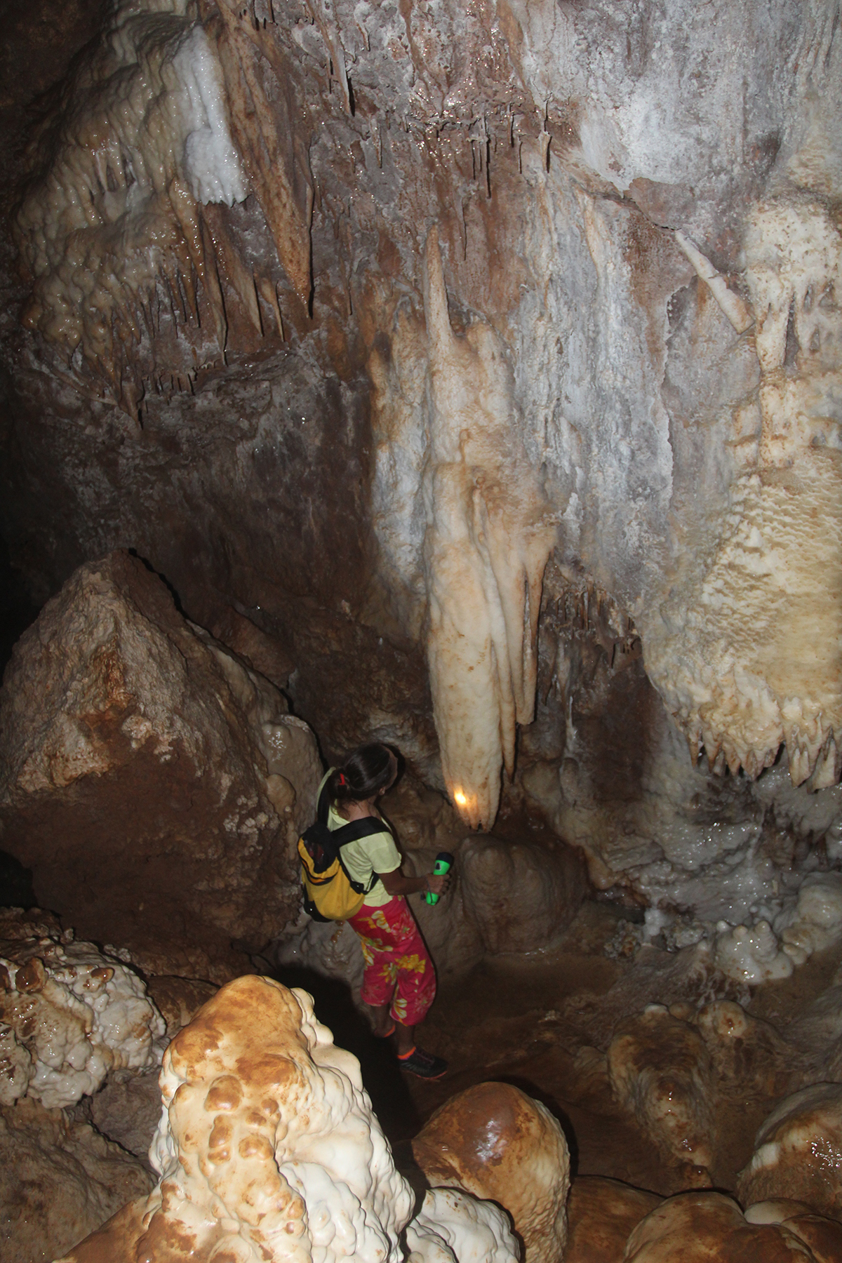 Comme jaillissant d’un drapé de calcite teintée par des oxydes de fer, une très belle stalactite tente de toucher le sol…