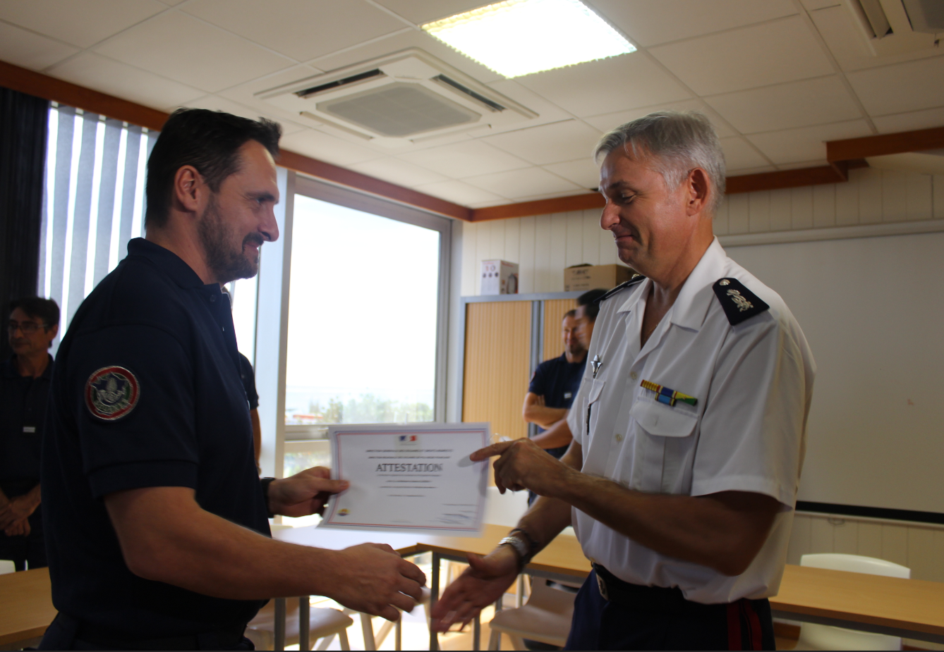 Richard Marie, directeur régional des douanes remettant l'attestation de stage "fouille des navires" au contrôleur Sam Loiseau.