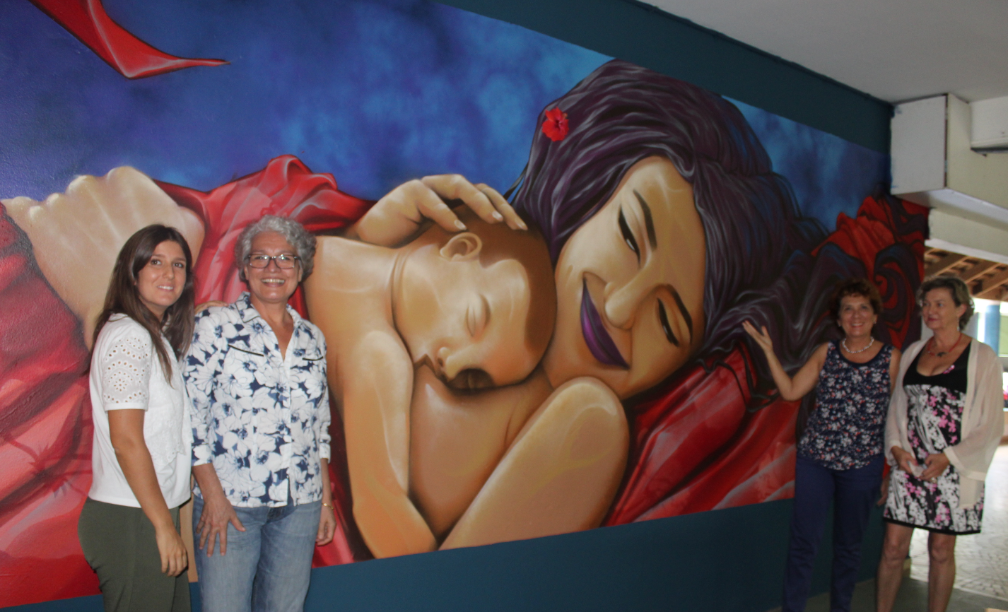 Sarah Brunet, Taimai Maamatuaiahutapu, le Dr Maire Tuheiava et le Dr Laurence Bonnac-Théron, devant la fresque toute neuve réalisée par Jops pour promouvoir l'allaitement.