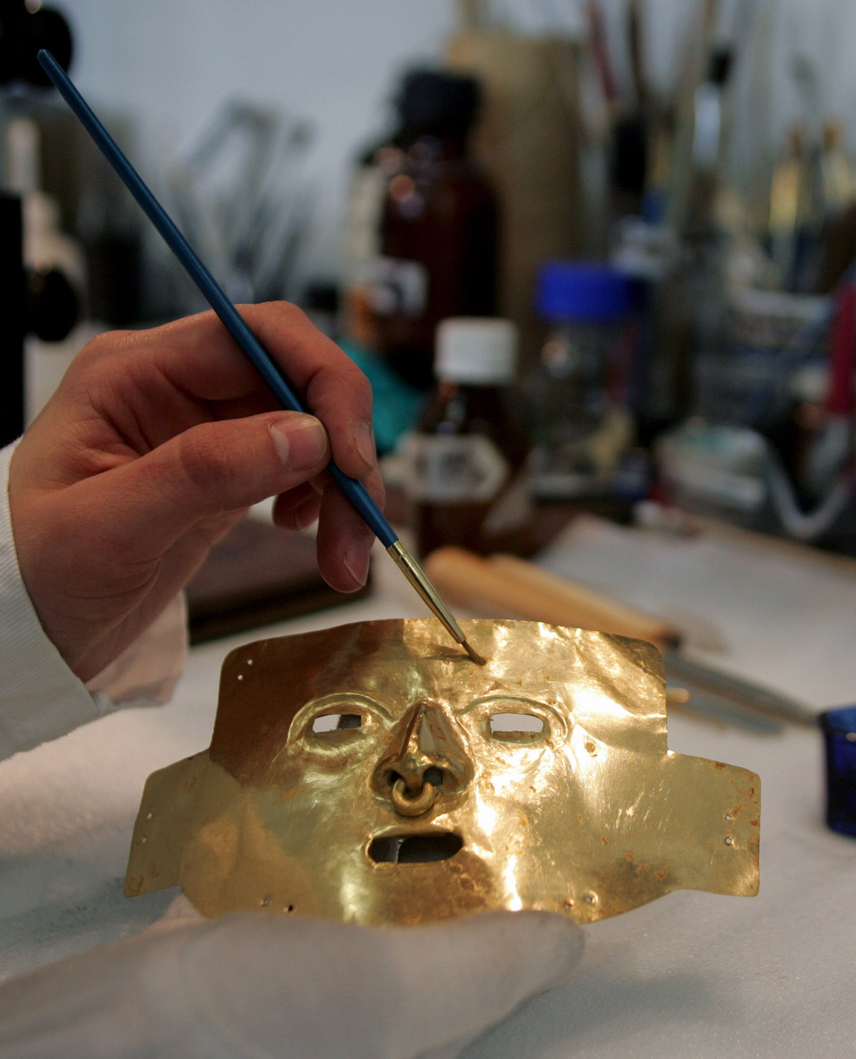 Un masque de la culture Tierradentro délicatement nettoyé avant d'être exposé.