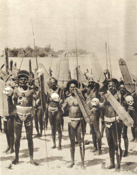 Cette photo ancienne de guerriers salomonais représente des chasseurs de têtes exhibant des crânes pris à leurs ennemis.