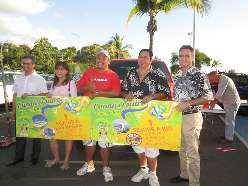Nos trois gagnants du jeu Anniversaire Carrefour, posant aux côtés d'Eric Corlier, directeur de Carrefour Punaauia.