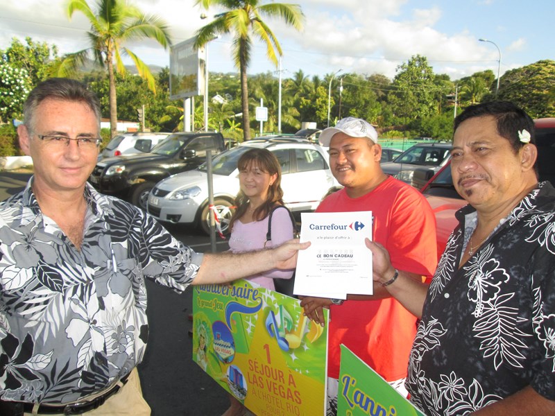 Georges Clark recevant son lot ( séjour à Rio) des mains d'Eric Corlier, directeur de Carrefour Punaauia.