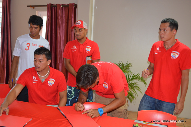 Après avoir dédicacé des ballons, les Tiki Toa signent des autographes dans le livre qui parle d'eux.