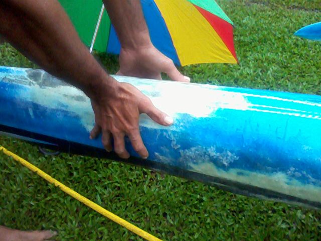 La victime montre avec ses mains la grandeur de la mâchoire sur la pirogue qu'il a réparée.