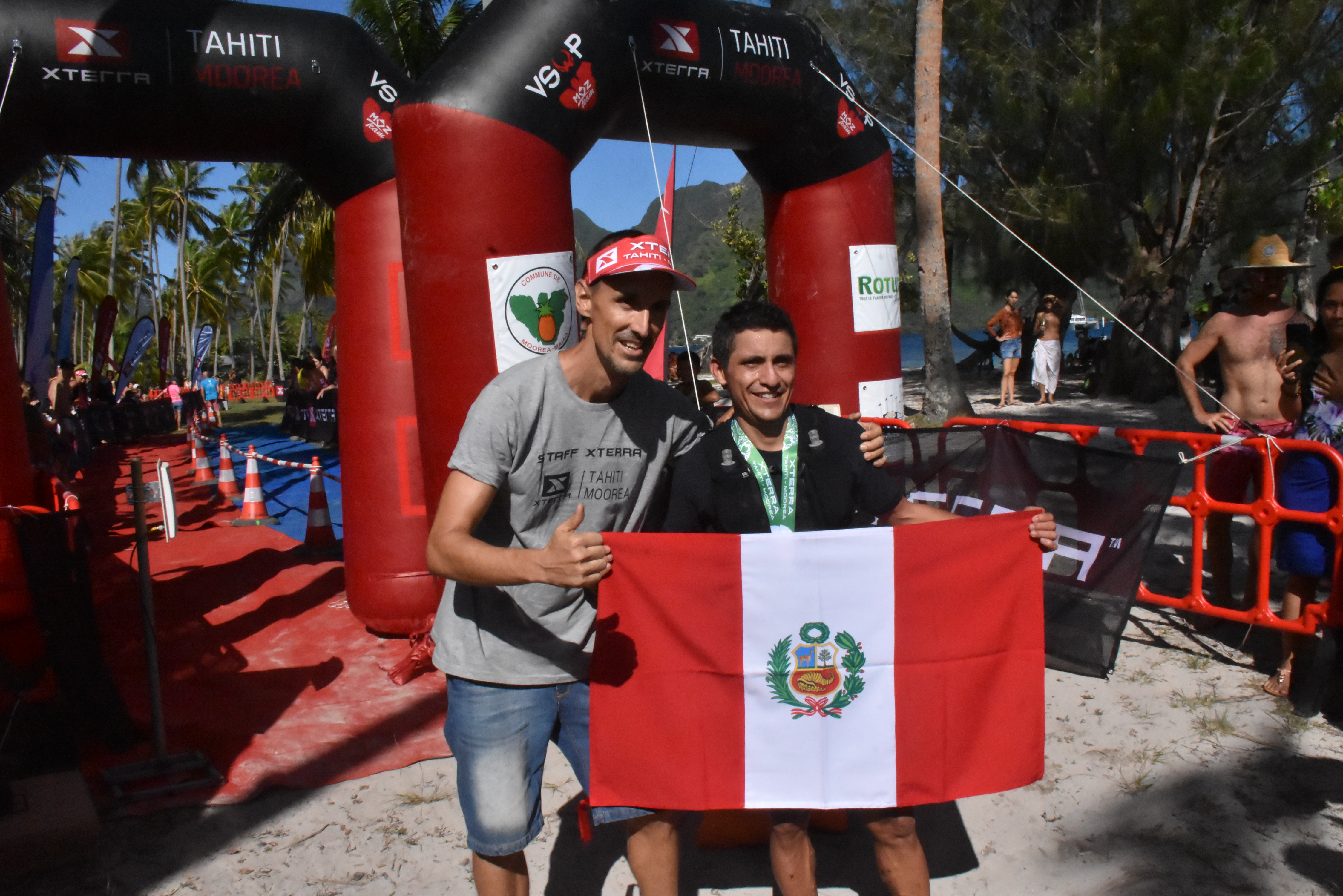 Le vainqueur du Tupuna Trail, Delbi Villa Gongora, sur la ligne d'arrivée sur la plage de Tahiamanu, aux côtés de Thomas Mourier, du club VSOP Moz organisateur du Xterra Tahiti.
