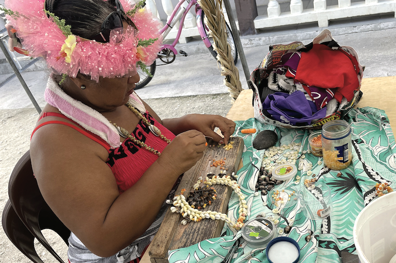 Irène, l'une des artisanes en train de créer un ras de cou pour le concours de parure de bijoux.
