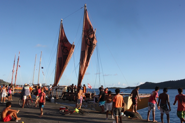 Les années passent mais les habitudes restent. Grands et petits sont attirés par les pirogues à quai qui profitent des dernières lueurs du jour pour terminer de charger des vivres. (Crédit : commune de Bora Bora)