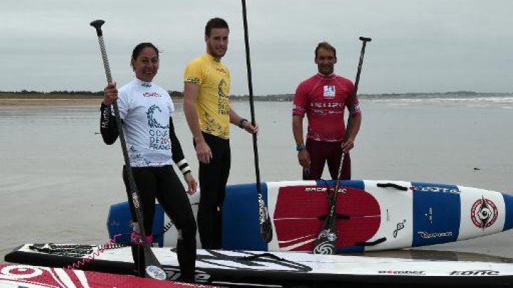 'équipe de France de stand up paddle, Céline Guesdon (g), Arthur Daniel et Eric Terrien posent sur la plage de Plouharnel (Morbihan) lors d'un entraînement, le 4 mai 2015. Photo : AFP