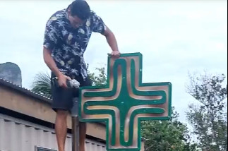 Teano Cojan qui essaye de couper le support de la croix de caducée avec une meuleuse, la mêche s'est cassée.