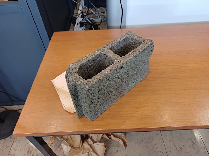 Le parpaing retrouvé au pied du lit de la victime.