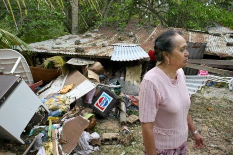 Une femme devant sa maison détruite par le cyclone Oli ( Photo AFP Gregory Boissy)