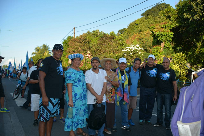 Le 17 mai 2014 à l'occasion du premier anniversaire de la réinscription de la Polynésie française sur la liste des territoires à décoloniser, Corbin Carlyle (au centre en T-Shirt blanc) participait avec Marie-Claude Tjibaou mais aussi d'Oscar Temaru et diverses personnalités politiques de l'UPLD au Tavini Tour à Tahiti.